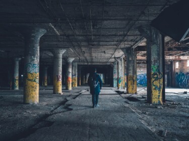 Photo by Andrew Amistad man walking hallway during daytime